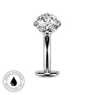 A polished silver-toned belly piercing bar with a large clear faceted gemstone, shown on a plain white background. A circular badge in the lower-left corner reads 'SKIN SAFE WATERPROOF AND TARNISH FREE' with a droplet icon.
