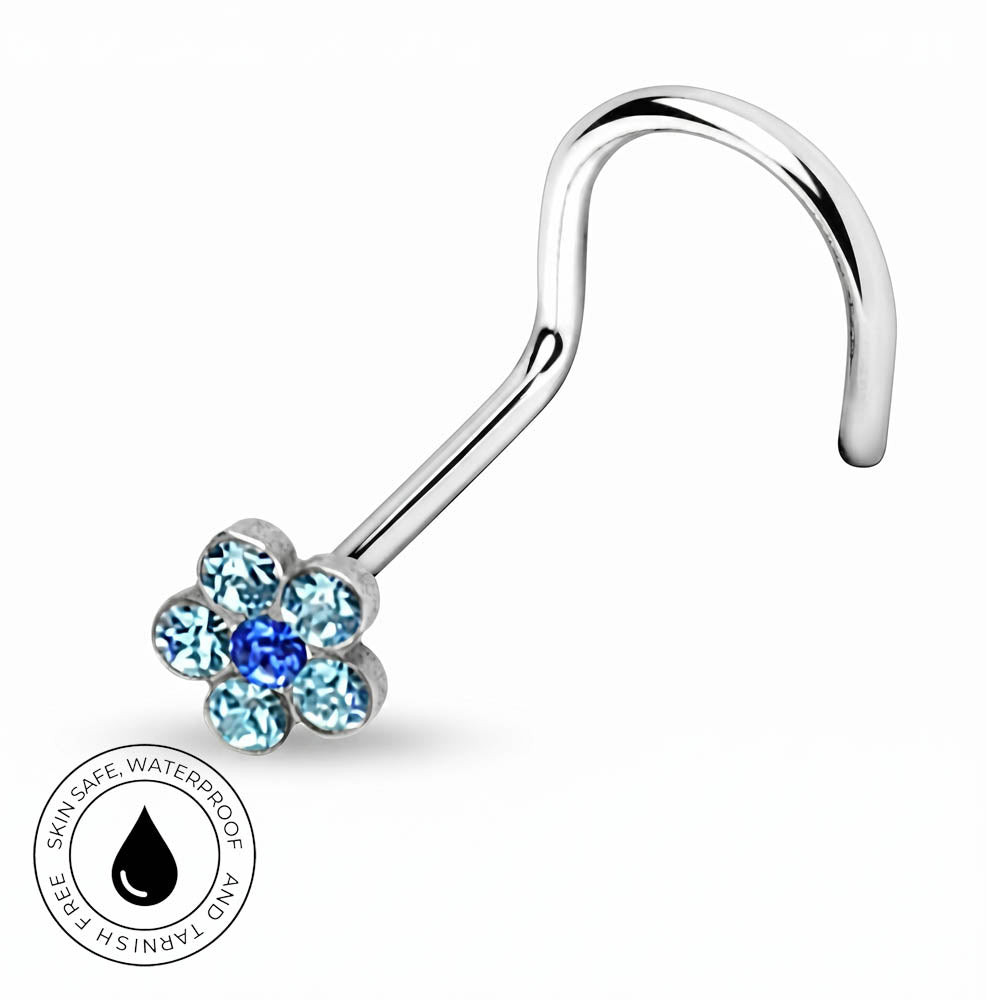 A silver-toned curved nose lobe ring with a flower-shaped crystal setting, featuring light blue and dark blue stones, shown on a white background with a circular 'Skin Safe Waterproof' badge.