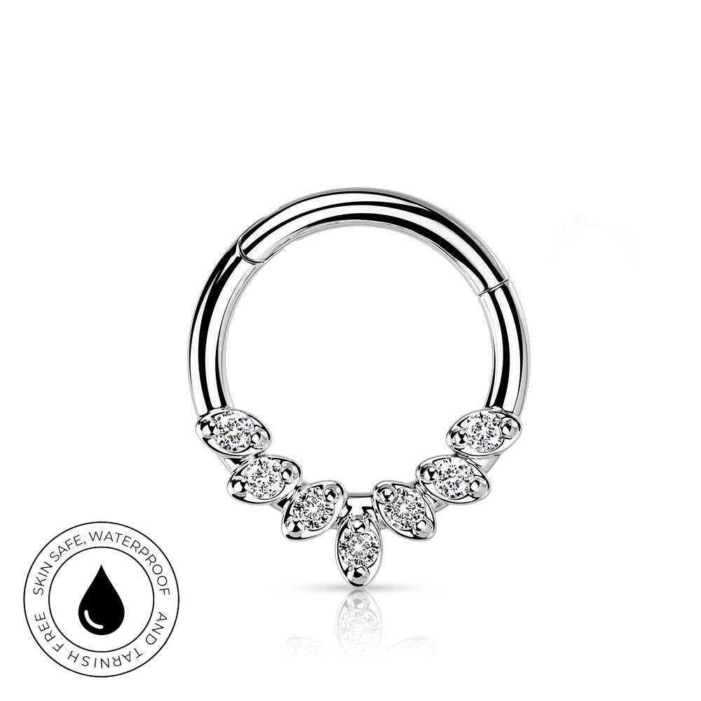 A silver-toned circular ring piercing with a decorative lower section featuring marquise-shaped clear stones, shown on a white background with a small circular 'skin-safe waterproof' badge in the lower left.