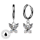A pair of silver hoop earrings with dangling butterfly charms set with clear sparkling stones, shown on a white background with a circular skin-safe waterproof badge in the lower left.