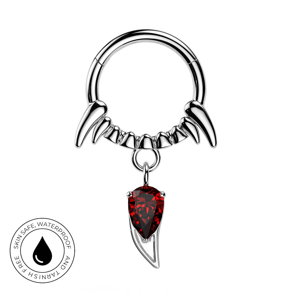 A silver-toned piercing ring with curved claw-like extensions and a dangling red teardrop gemstone, shown on a plain white background with a circular 'skin-safe waterproof and tarushi free' badge in the lower left.
