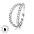 A silver-toned double-band ring with clear pavé stones on a white background, featuring a circular inset badge that reads 'SKIN SAFE WATERPROOF' and 'TARNISH FREE'.